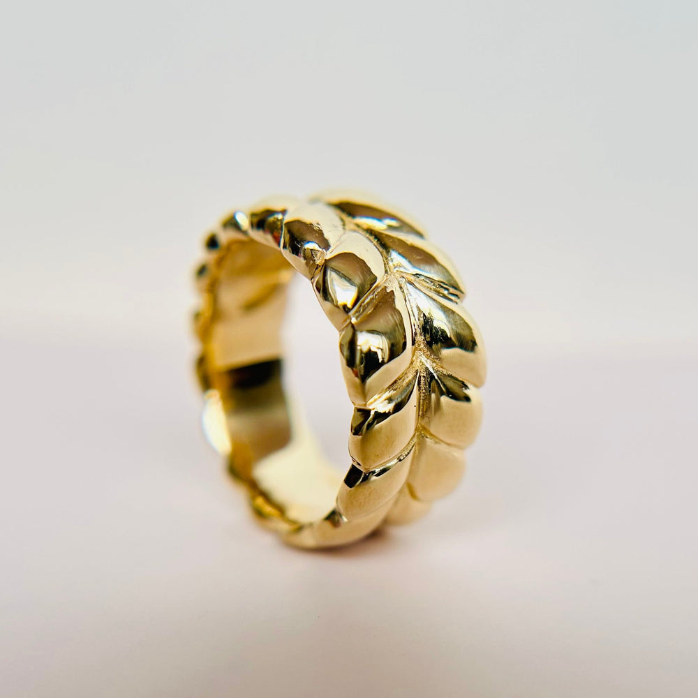 
                  
                    A braided gold ring, shown on its side.
                  
                